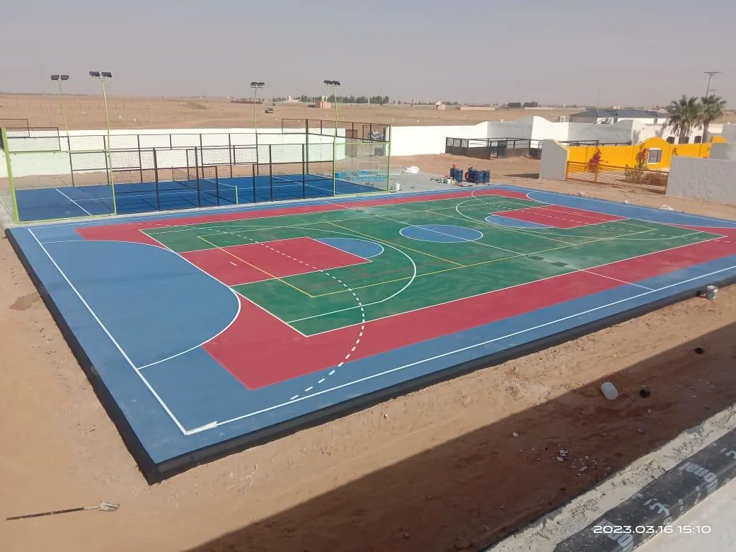 ملعب خارجي متعدد الاستخدامات بأرضية زرقاء وحمراء وخضراء